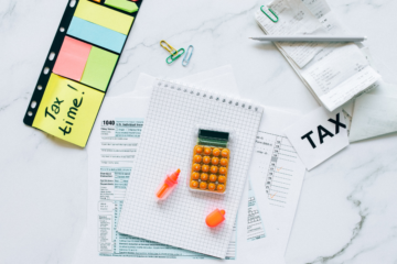 formuláre, bločky, kalkulačka a farbené lepky s nápisom tax time