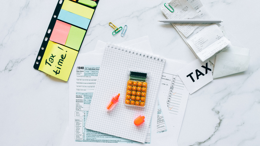 formuláre, bločky, kalkulačka a farbené lepky s nápisom tax time