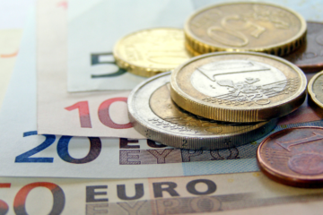 euro bankovky a mince položené na stole